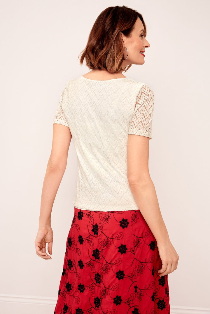 Lily Ella Collection cream chevron lace top paired with a vibrant red floral skirt, showcasing elegant women's fashion.