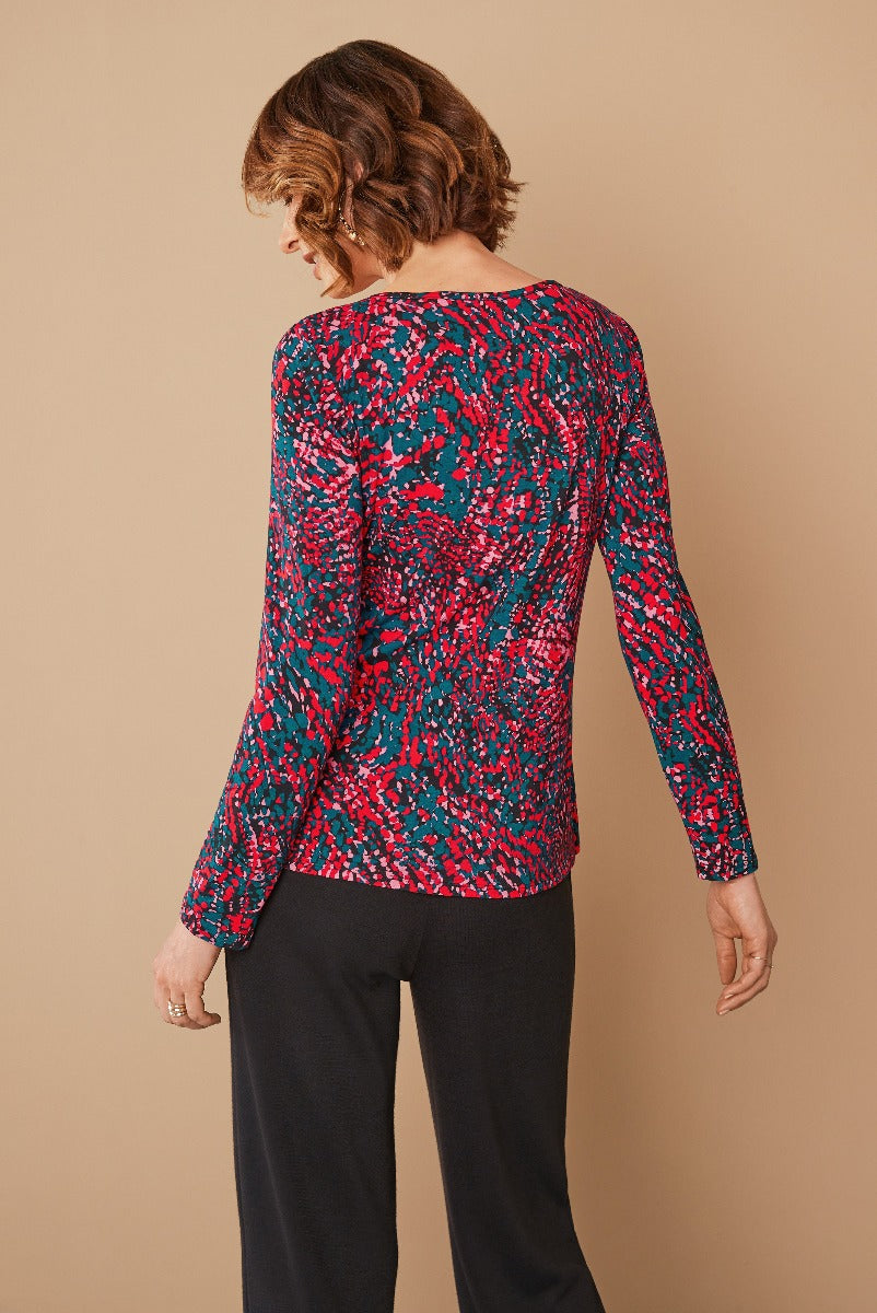 Lily Ella Collection blue and pink abstract print women's top with long sleeves paired with classic black trousers, elegant casual wear, fashion outfit idea.
