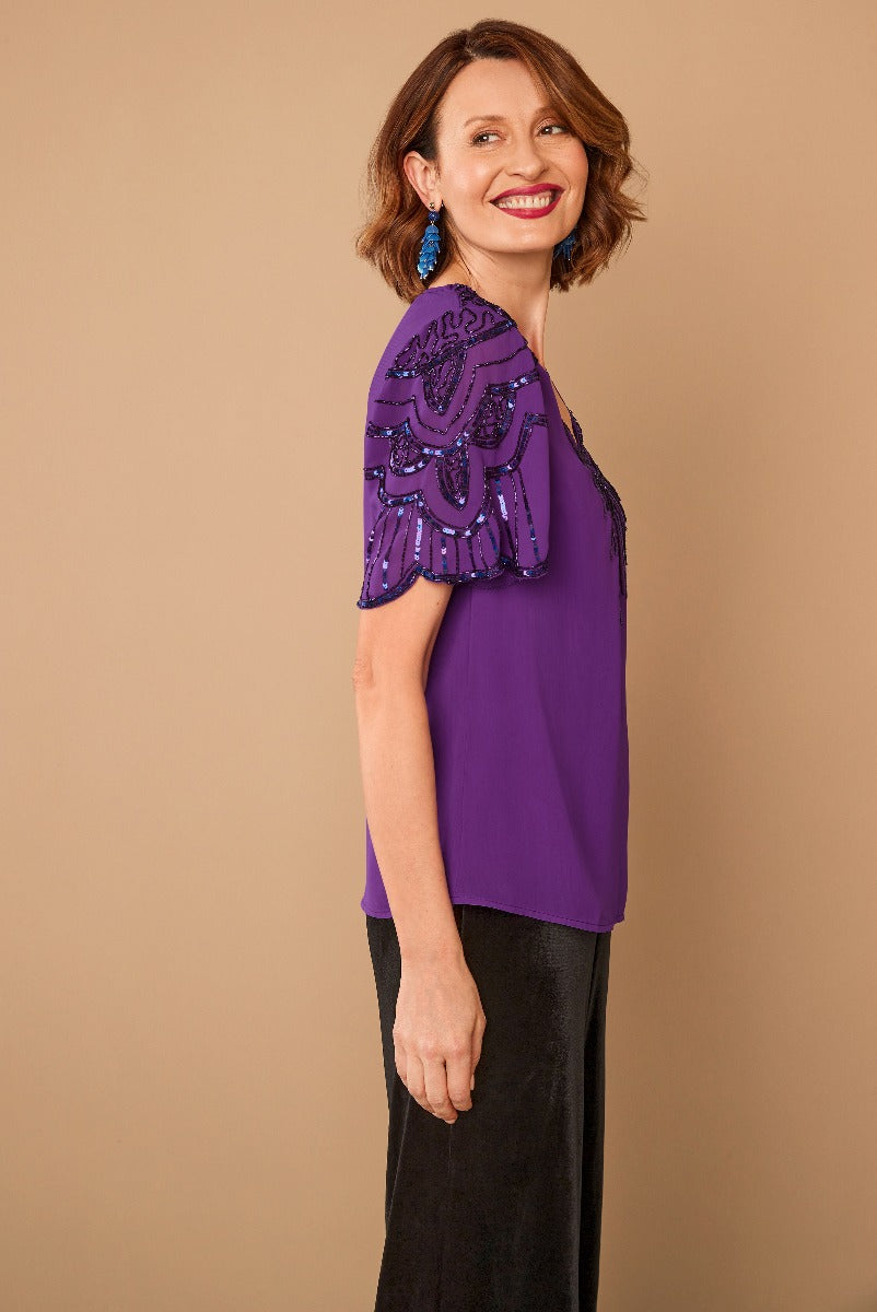 Lily Ella Collection elegant purple embellished top with beaded details, paired with classic black trousers, perfect for sophisticated evening wear