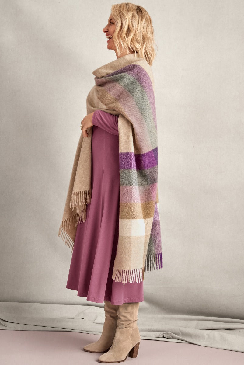 Lily Ella collection elegant woman in mauve skirt and stylish checkered wrap scarf with beige suede boots, showcasing contemporary autumn fashion.